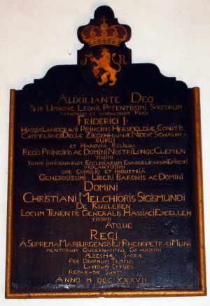 Eine hölzerne Inschriftentafel in lateinischer Sprache erinnert an die Restaurierung der Kirche unter Landgraf Friedrich I von Hessen-Kassel und Freiherr Christian Melchior Sigismund von Kurzleben Bild der Inschriftentafel